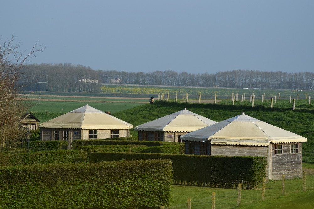 De drie blokhutten van 't Kuyperke tussen de buxushagen in de dijktuin